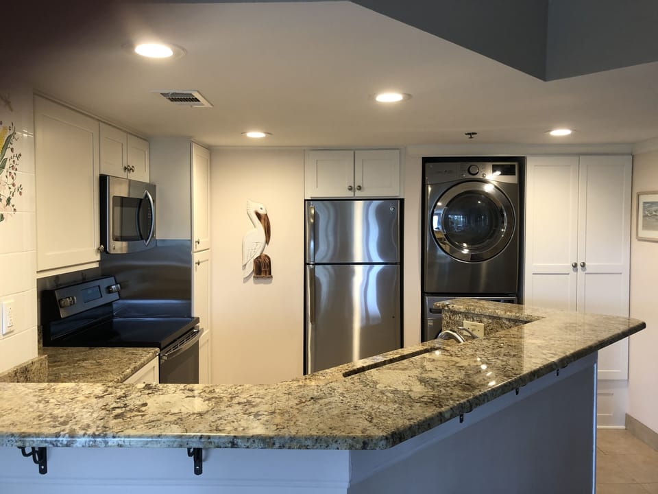 Kitchen with new Stainless appliances and high capacity washer and dryer.