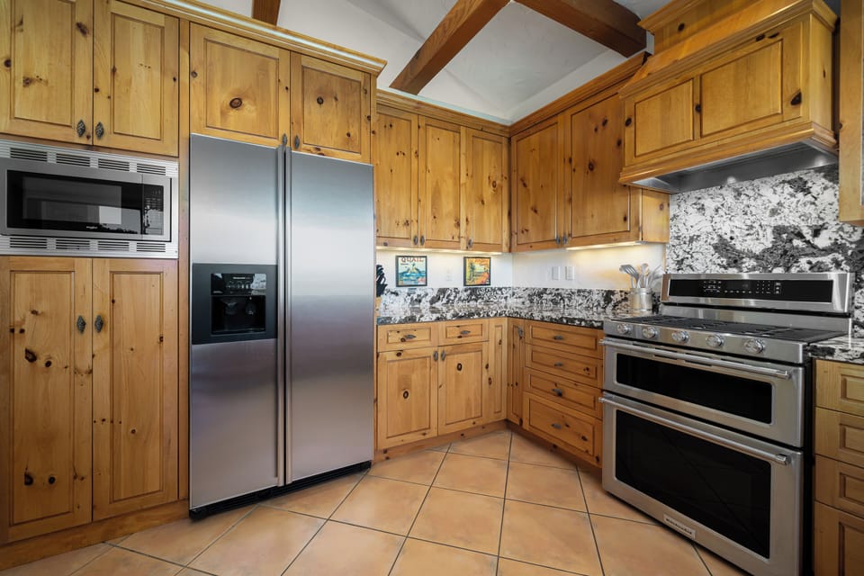 Gourmet kitchen with gas cooktop & double oven with pop of blue enamel interior 