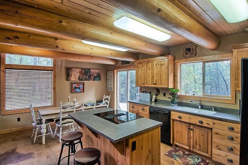 Kitchen looks out to pool and forest