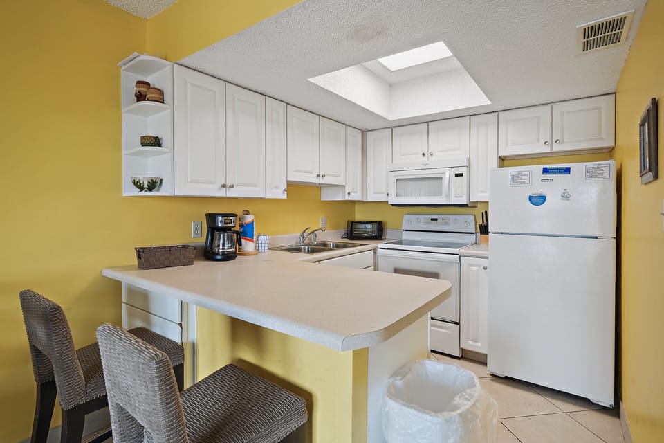 Fully equipped kitchen with stove, microwave, dishwasher, toaster, and utensils.