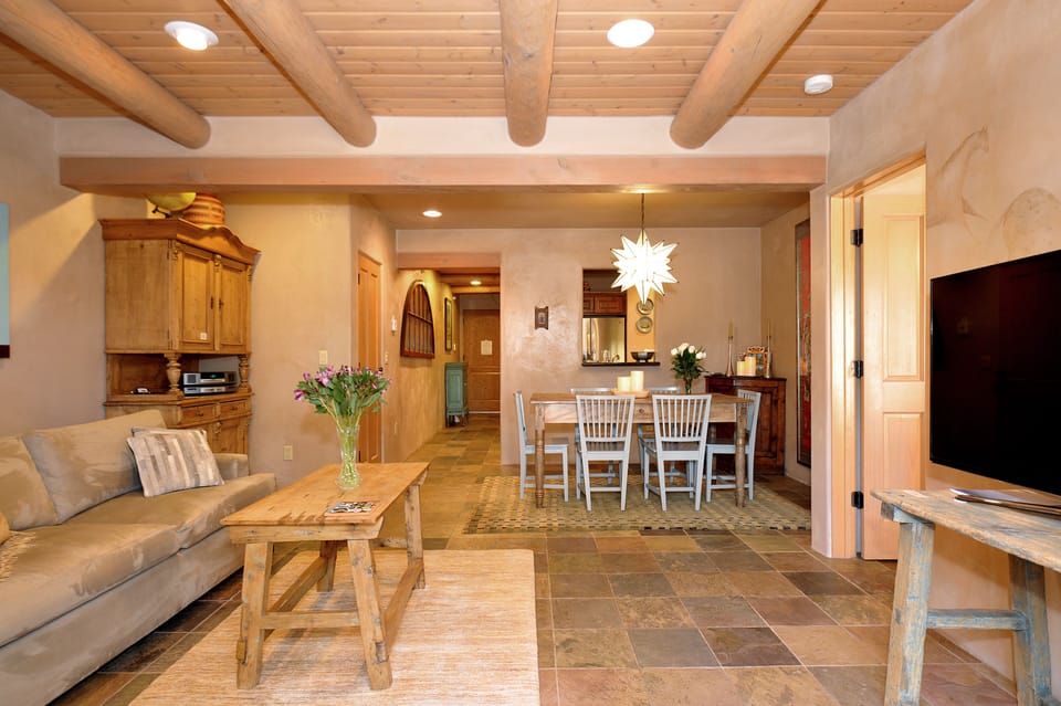 Looking at living room, dining room, and hall, standing in front of patio doors.