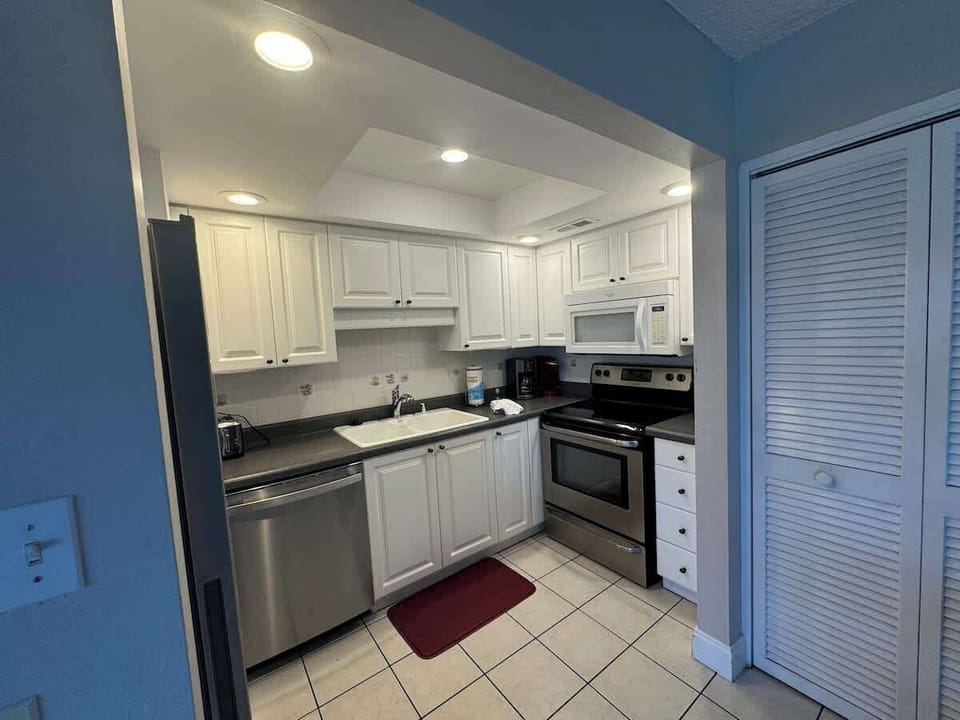 Fully-stocked kitchen with plenty of space, appliances, utensils, and cookware.