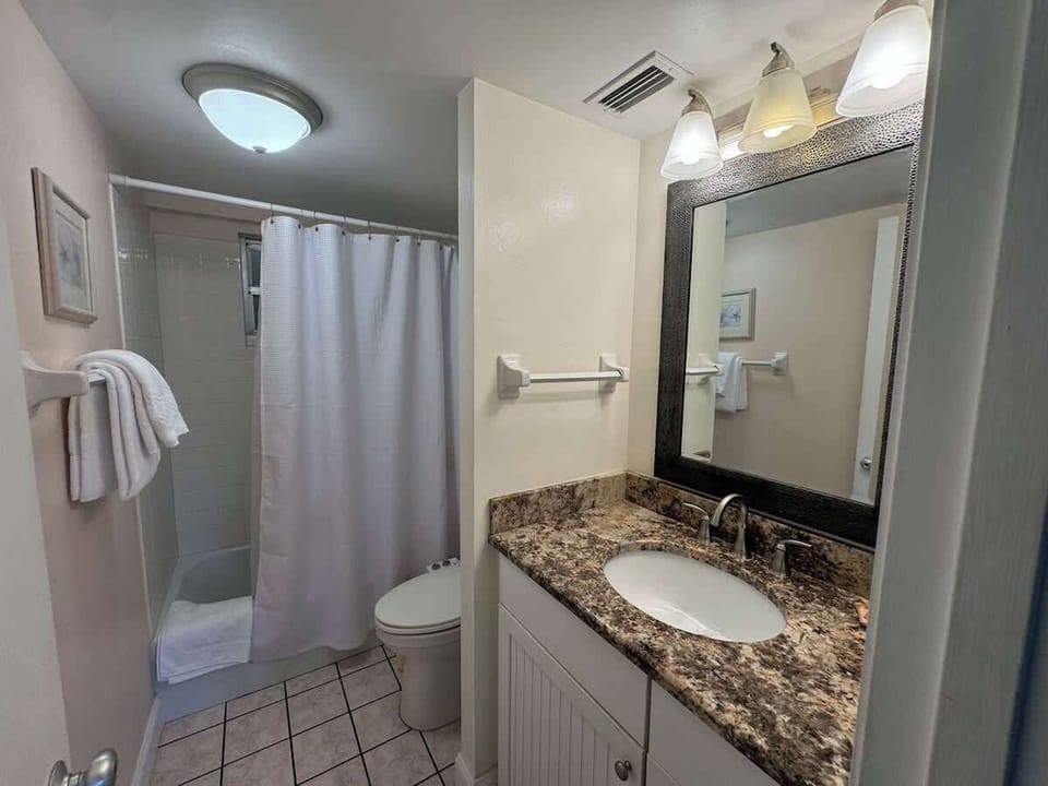 Updated guest bathroom with comfort-height granite countertop, tub, shower.