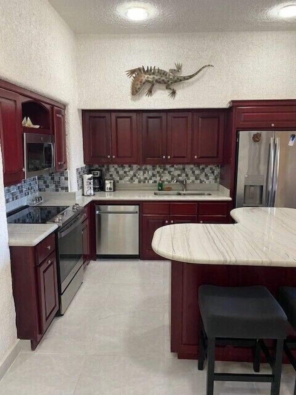 Remodeled kitchen with beautiful marble countertops and island.