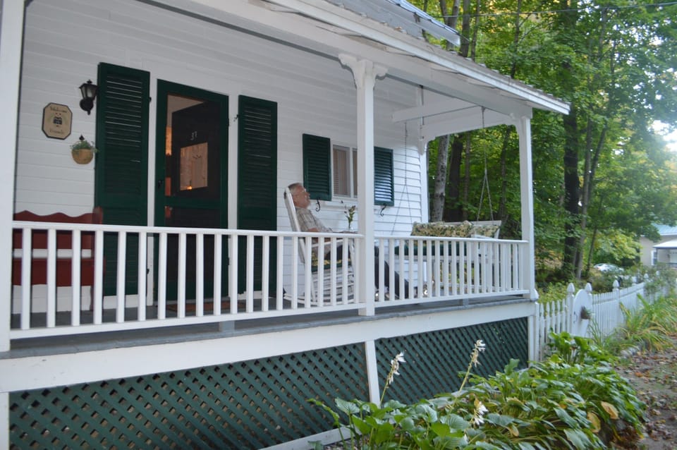 A porch swing and rocking chair host you on the house-length front porch.  