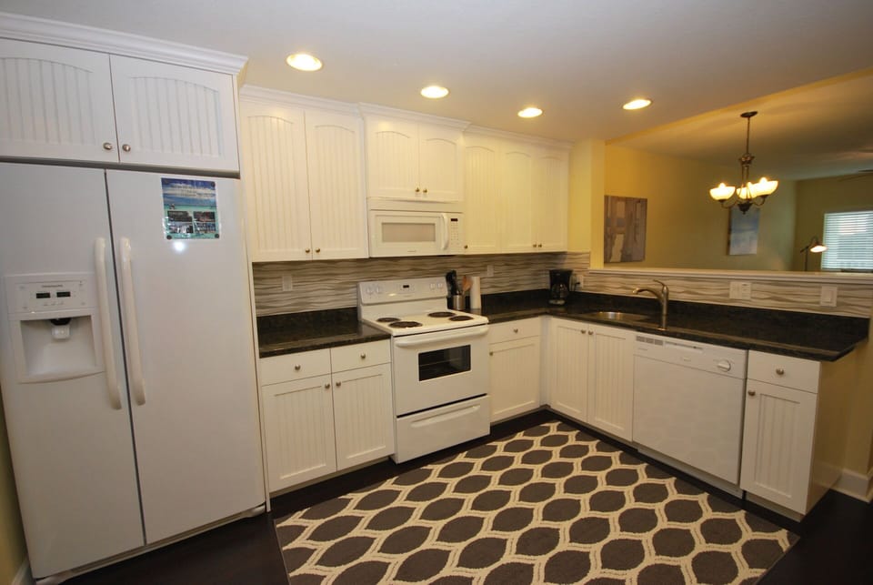 The fully equipped kitchen with granite counter tops, plates, silverware, etc.