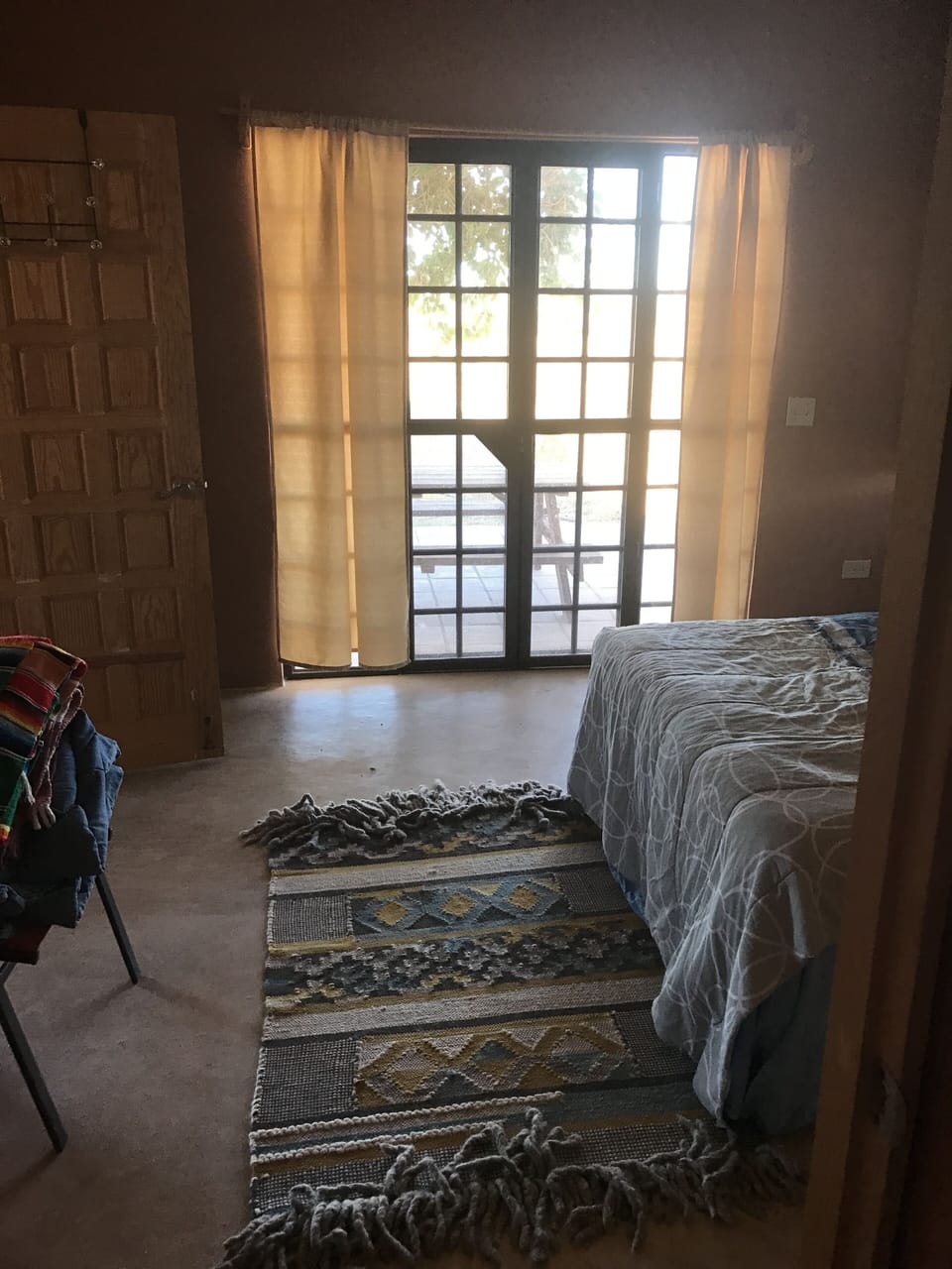 view from bedroom with double doors to pool