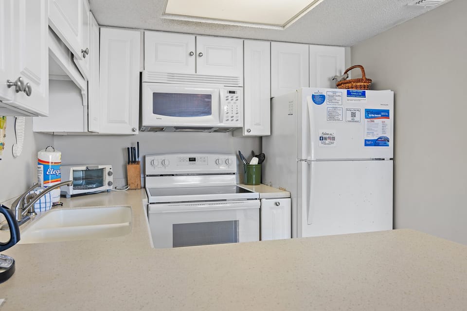 Fully equipped kitchen with stove, microwave, dishwasher, and utensils.