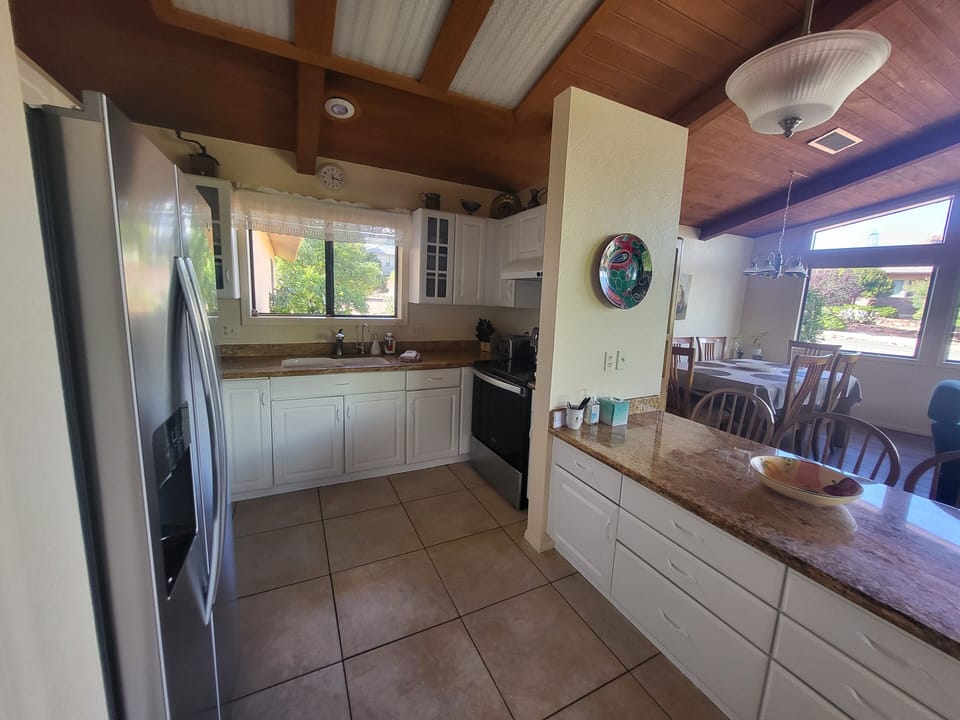 Kitchen fully equipped- low bar seating for 4, opens to dining area, living room