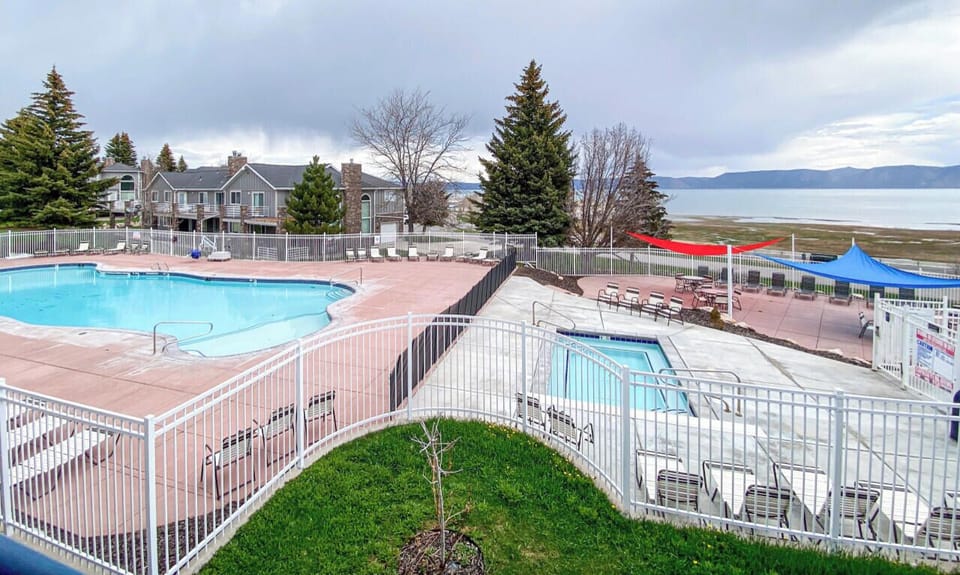 Seasonal sunny poolside retreat with stunning lake views—perfect for a relaxing swim or lounging outdoors.