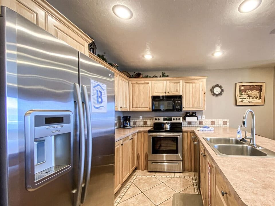 Bright kitchen featuring stainless appliances and natural wood finishes