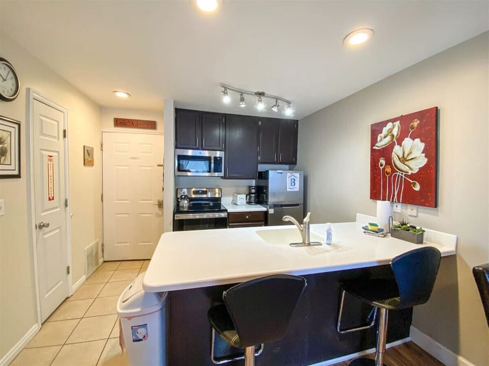 Modern kitchen with sleek dark cabinets and a bright island perfect for casual dining and conversation
