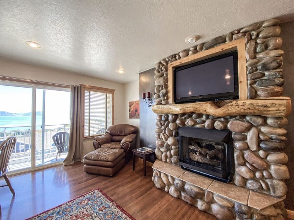 Comfortable seating area beside fireplace with balcony views