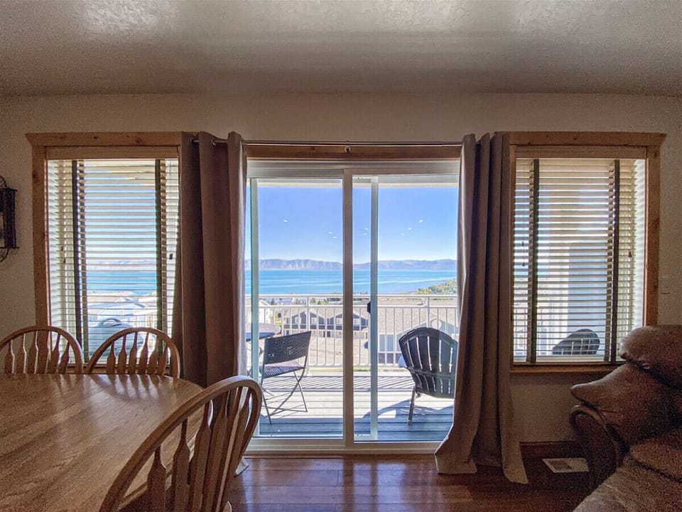 Bright dining space opening to scenic balcony overlooking the lake