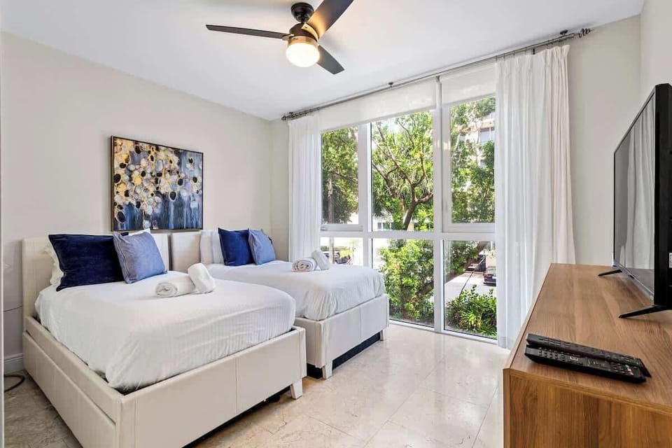 The guest bedroom has two twin beds an a flat screen TV