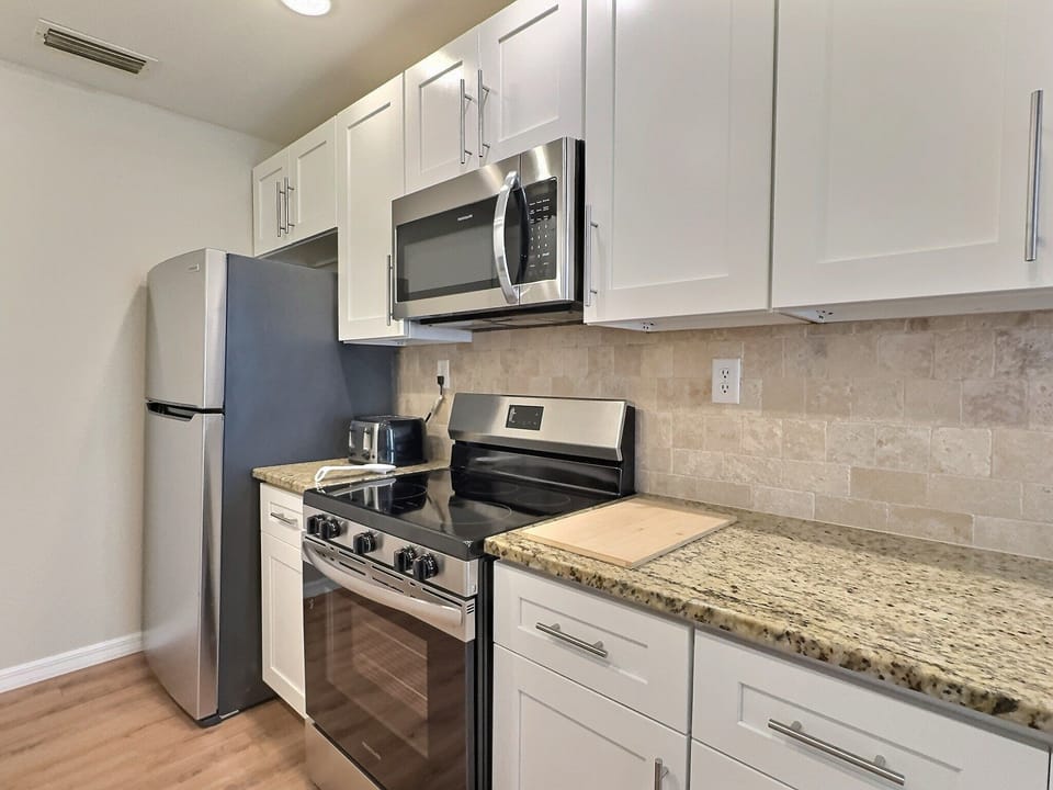 The kitchen showcases stainless steel appliances and sleek countertops for gourmet meal preparation.