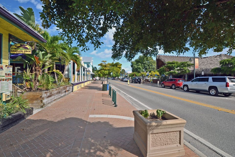 Charming main street of Siesta Key Village lined with shops, restaurants, and tropical landscaping