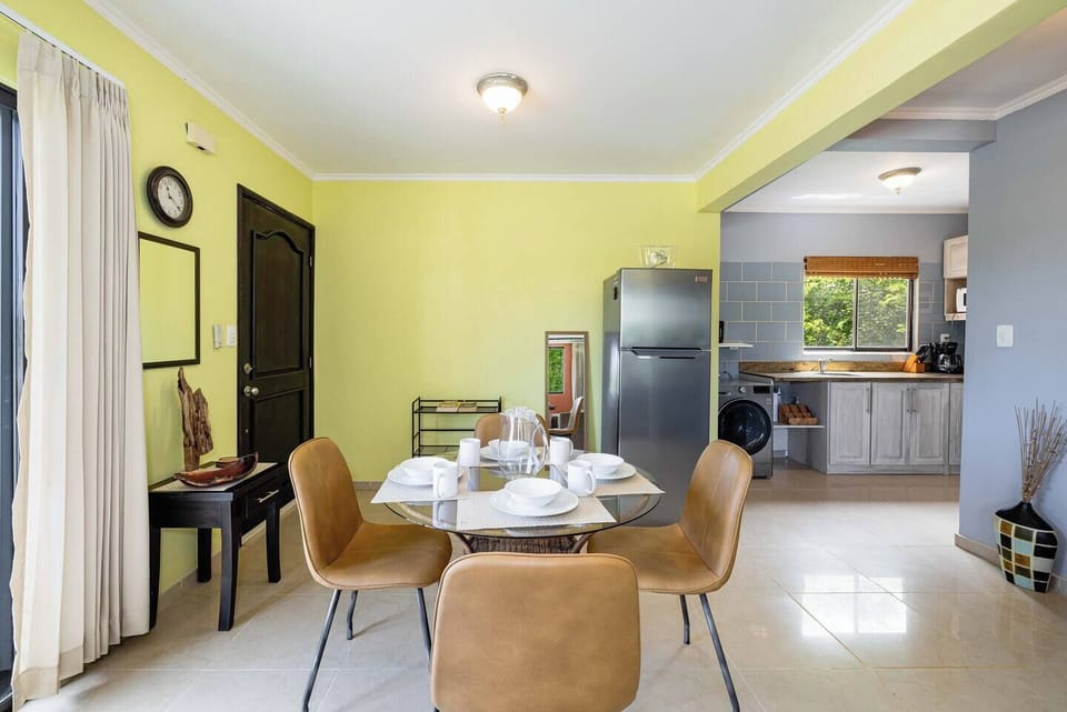Bright dining area with a stylish table and seating, ideal for enjoying meals with family or friends during your Tamarindo vacation rental near the beach.