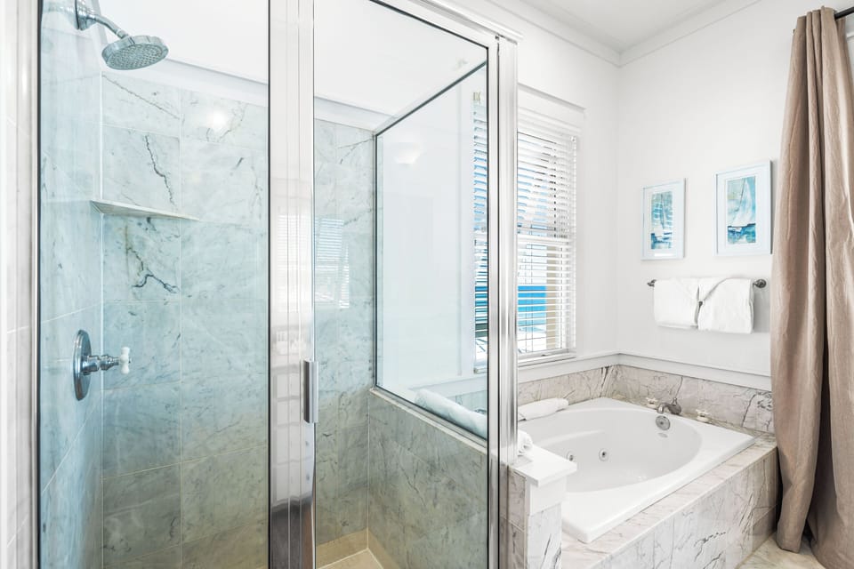 Walk-in shower and a large jetted soaking tub in this primary beachfront bathroom.