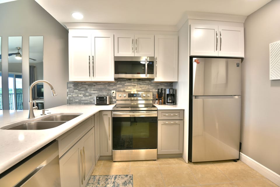 Kitchen with stainless refrigerator, sink, and updated cabinetry
