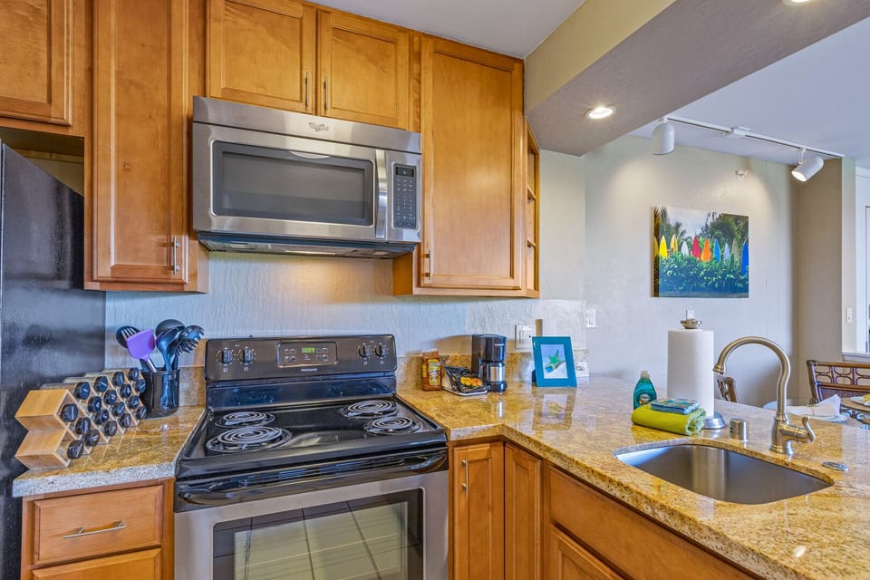 kitchen with stove and oven, microwave and granite counter tops
