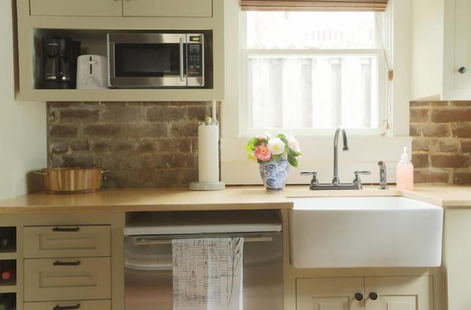 A beautiful farm house sink and bright cabinetry.