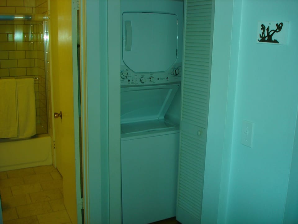 Brand new stacked washer-dryer unit in hallway closet