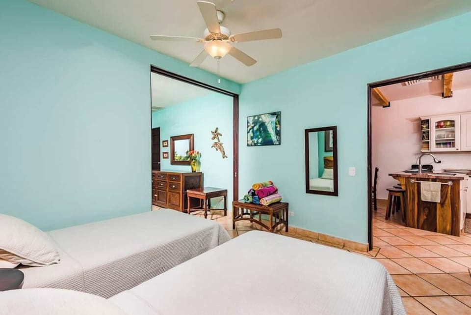 Twin-bed guest room designed for comfort and flexibility — great for traveling surfers, digital nomads, or small families. Connected to the master bedroom in a stylish Tamarindo condo near the ocean.