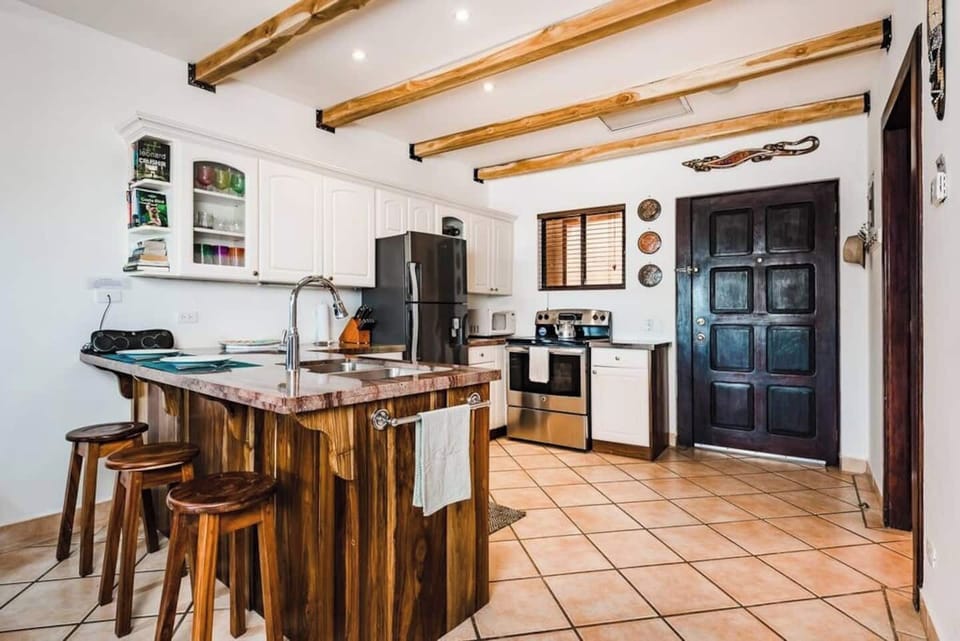 Fully equipped kitchen with rich wood countertops, modern appliances, and open shelving — perfect for cooking fresh local meals or blending smoothies after the beach. A stylish and functional space in the heart of Tamarindo.