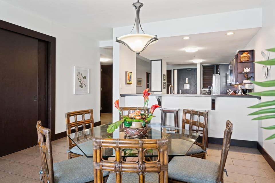Enjoy this open dining space with rattan seating and seamless access to the kitchen and bar area.