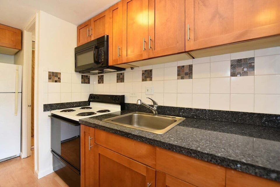 Compact yet elegant kitchen with stainless steel accents and natural wood tones for a warm, inviting feel