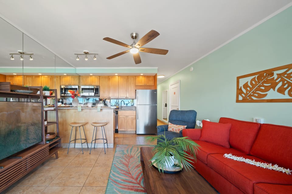 Bright living area with ceiling fan, seating, and open layout.