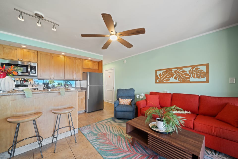Comfortable living area with sleeper sofa, ceiling fan, and open layout.