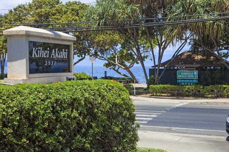 Kihei Akahi property entrance surrounded by greenery and palm trees.