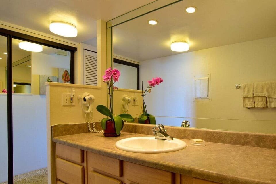 Enjoy a well-lit vanity with a full wall mirror and ample room to get ready comfortably during your stay
