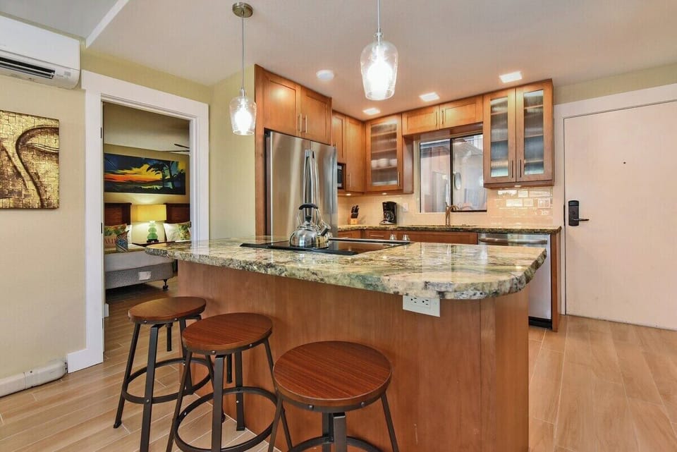 Stylish kitchen with granite counters, stainless steel appliances, and bar seating for casual meals.