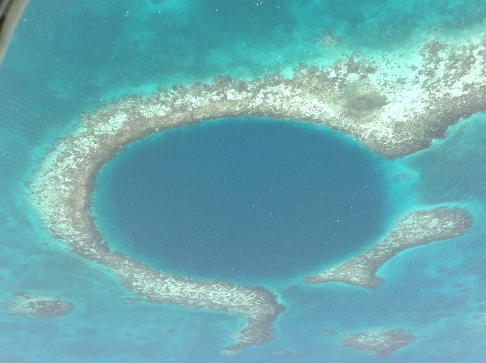 Either dive or fly over the famous Blue Hole