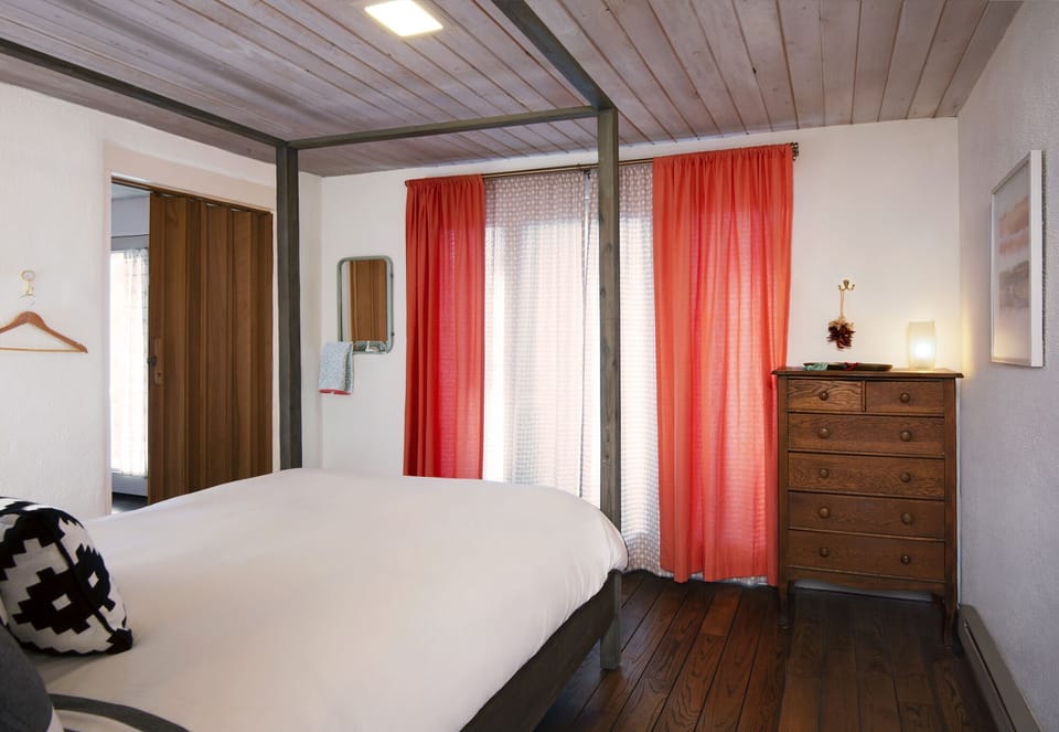 Bedroom with queen bed: French doors open to entry walkway