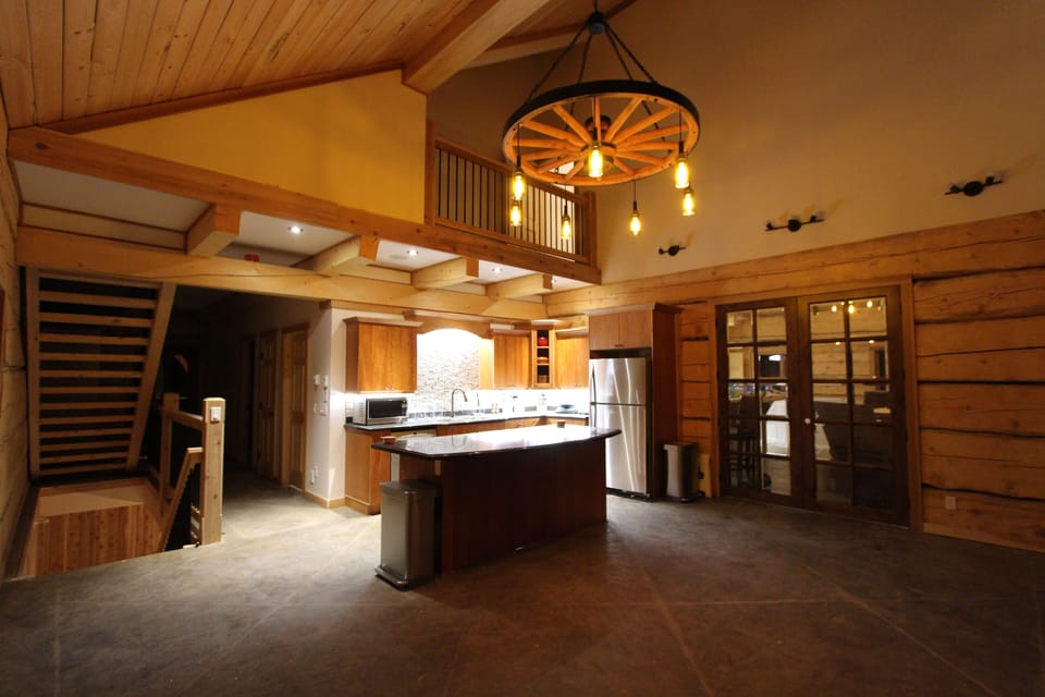 The fully equiped kitchen has large island, hanging wagon wheel chandelier and