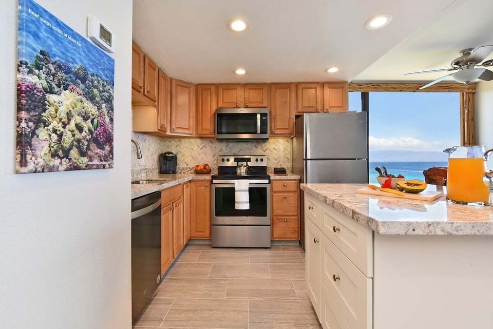Spacious fully equipped kitchen with stainless steel appliances, wooden cabinetry and quartz countertop