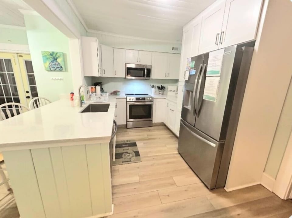 Spacious kitchen with modern stainless steel appliances.