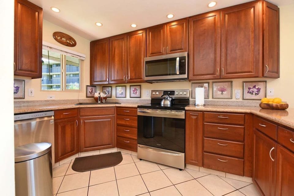 Spacious kitchen features stainless steel appliances, wood cabinetry and granite countertop