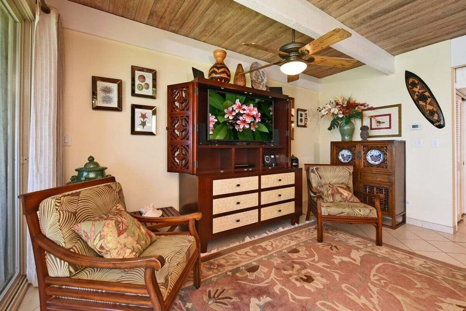 Charming entertainment corner with island‑inspired furniture, detailed woodwork, and a large TV for relaxing evenings