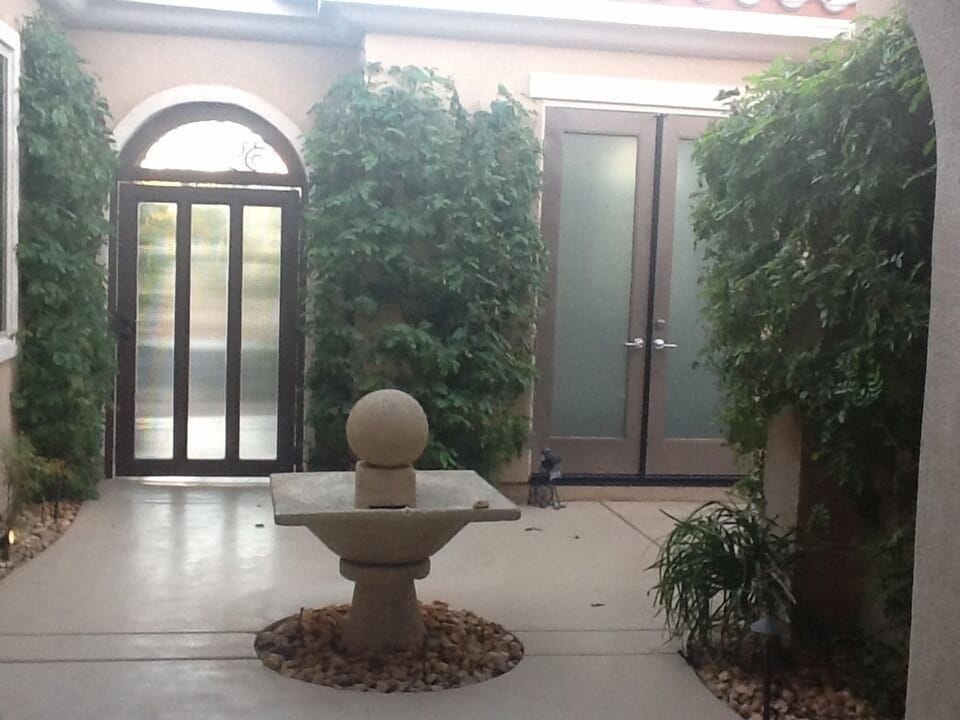 Privacy gate from street to courtyard and double doors leading to casita