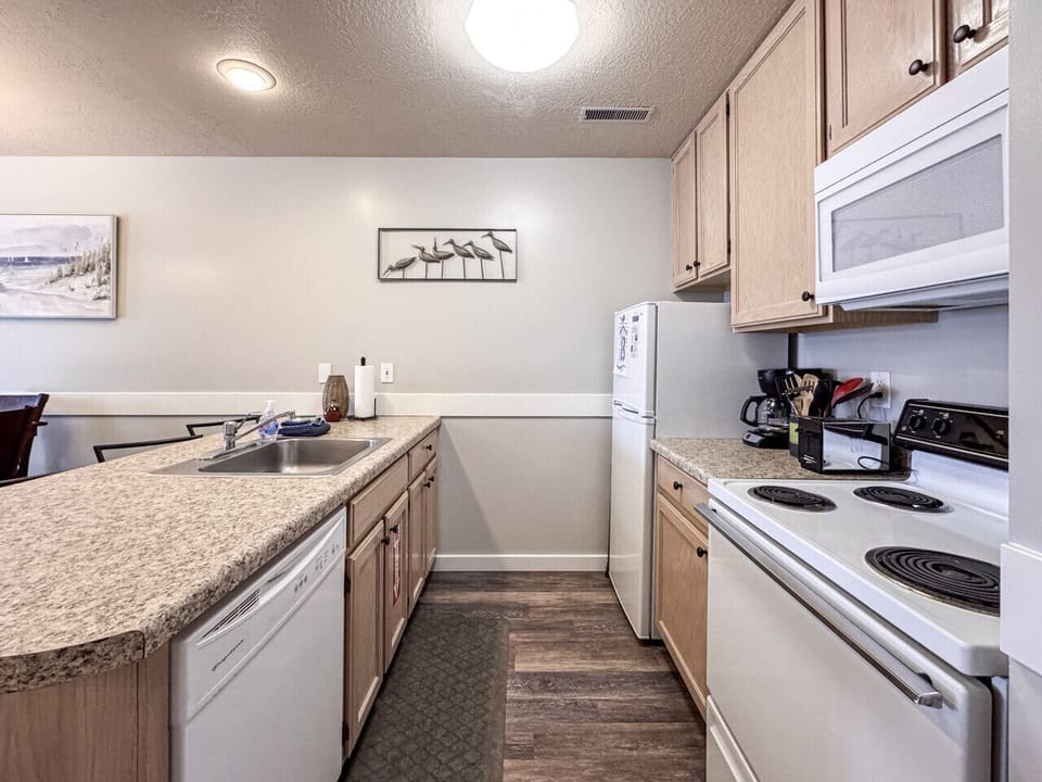 Bright, fully-equipped kitchen with ample counter space—perfect for preparing meals and gathering together.