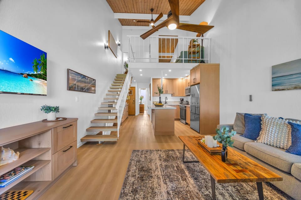 The open floor plan highlights the beautiful craftsmanship and design of the home, showcasing the dramatic spiral staircase and the functional loft area above