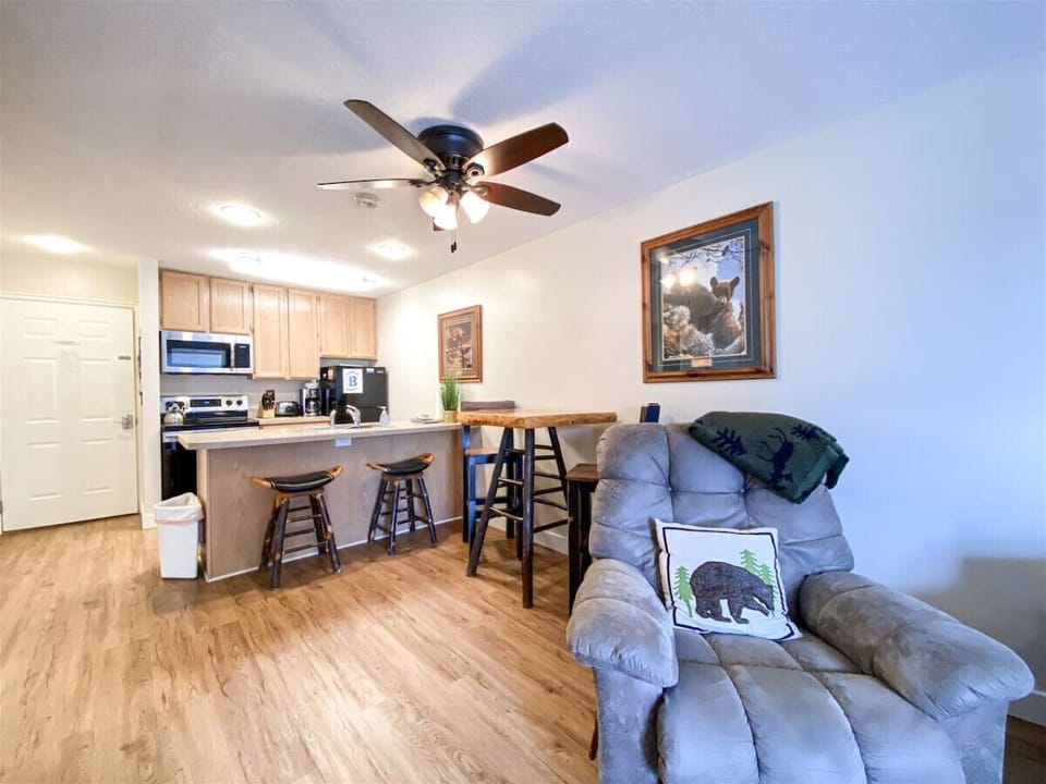 Cozy open-concept kitchen and lounge with rustic charm and comfy recliner—perfect for unwinding.