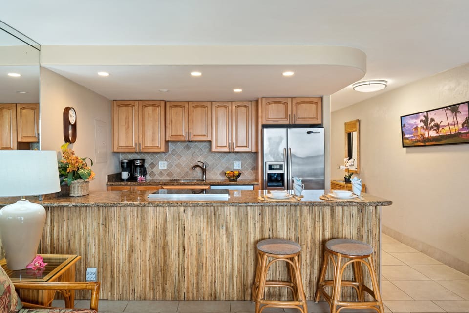 Fully equipped kitchen with bar seating and warm wood finishes.