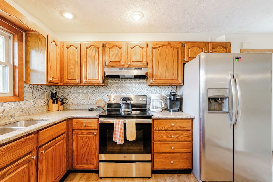 Large refrigerator in main kitchen w ice maker, spare fridge in kitchenette.
