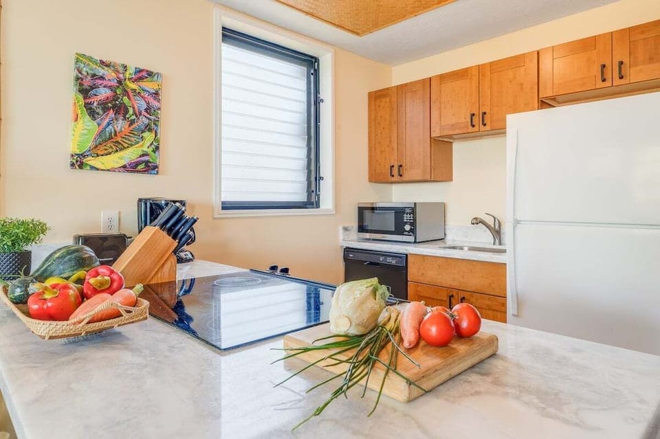 A modern kitchen with marble counters, wood cabinetry, and fresh ingredients ready for easy vacation cooking
